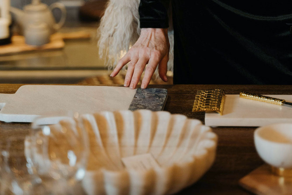 A customer&#39;s hand touching a gift registry product at L.V. Harkness