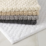 Lotus White Small Bath Rug These supple, honeycomb-patterned bath rugs will coordinate with select colors in our Lotus towel collection. The Lotus bath rug is a luxurious choice for the master bathroom - the cotton yarn is not only highly absorbent, it also gets softer and fluffier the more you wash it.